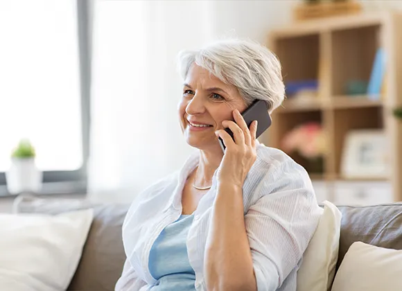 Ältere Dame sichtlich fröhlich am Telefon